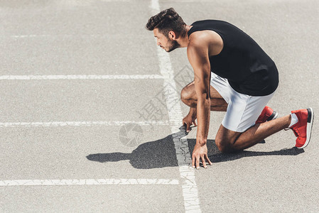 年轻男运动员在赛道上低起图片