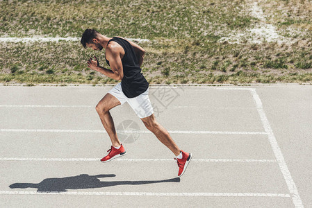在运动场运动赛道上跑步的男短脚图片