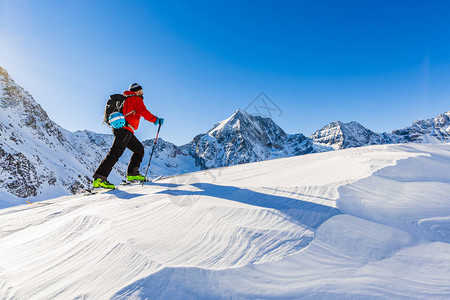 登山者偏远地区滑雪沿着雪脊行走图片