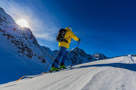 登山者偏远地区滑雪沿着雪脊行走图片