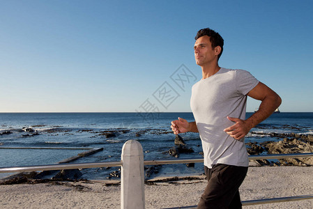活跃的中年男子在海边奔跑的肖像图片
