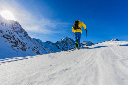 登山者偏远地区滑雪沿着雪脊行走图片