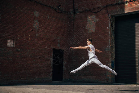 在城市街道上跳跃的年轻芭蕾舞演员图片