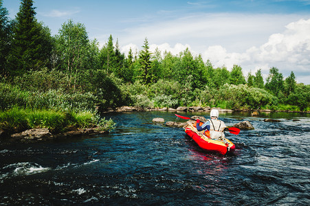 乘坐充气红色皮划艇在湍急的河流上进行极限漂流背景图片