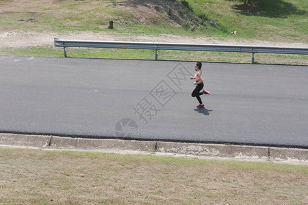 女运动员跑步者在春季或夏季户外慢跑图片