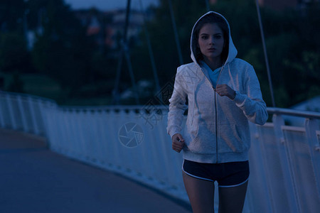 夜间在公园里奔跑的蒙面年轻女子健身和锻炼健康概念户外运动图片