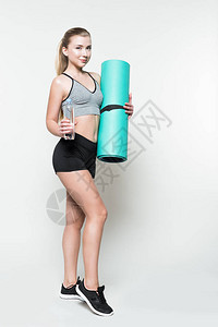 女运动员拿着水瓶和瑜伽垫被白色隔开图片