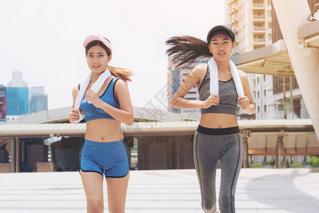两个健康的女人在城市背景下奔跑女健身健康城市生活方式和城图片