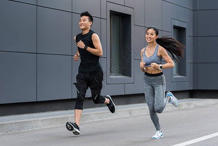 在城市街头奔跑的亚裔男女运图片