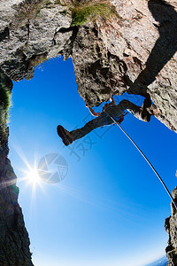 攀岩男登山者在陡峭的悬崖上阳光明媚图片