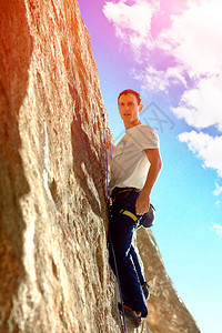 年轻人爬在岩石墙上图片