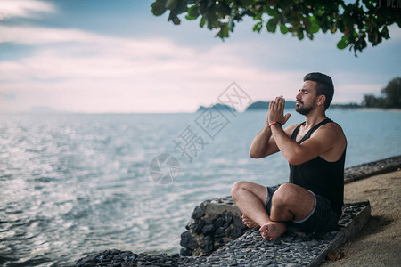 年轻人在海边做瑜伽一个帅哥日落图片