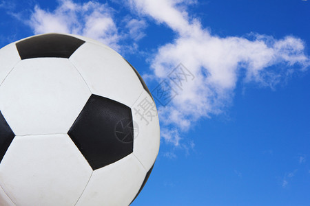 黑色和白色足球对着夏季蓝色天空复制文本图片