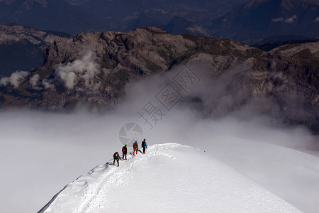 一群登山者爬上了一座雪山图片