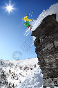 滑雪者从高山的悬崖上跳下空中图片