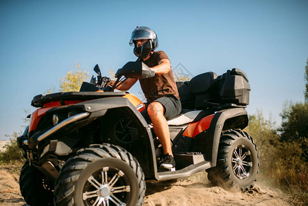 戴着头盔的亚视车手骑在森林里的沙路上骑四轮摩托车极限运动和旅行四图片