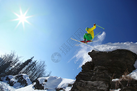 滑雪者从高山的悬崖上跳下空中图片