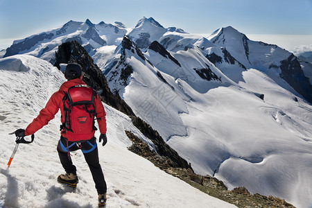 Mountaineer沿着Breithorn的白雪皑的山脊往下走图片