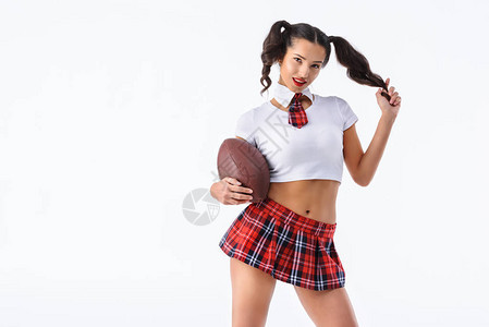 带着美式足球的有魅力的年轻女学生图片