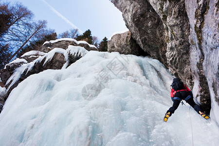 陡峭冰瀑上的攀冰者水平的西阿尔卑斯山图片