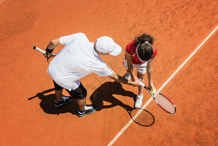 网球教练与青少年球员一起工作图片