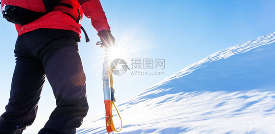 克服挑战的概念登山者面临攀登雪峰顶部图片