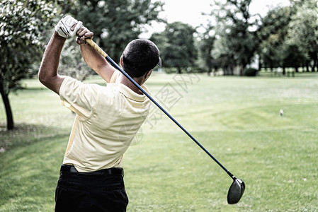 高尔夫球手在高尔夫球场完成他的一号木挥杆背景图片
