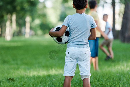 非裔美国儿童站在靠近男孩的足球场图片