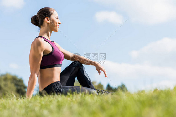 青年女运动员坐在草地上图片