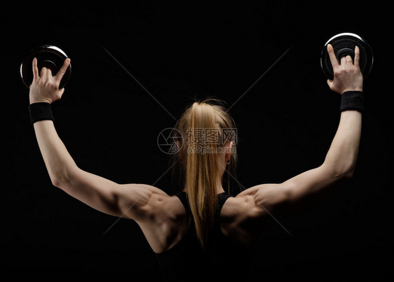 年轻瘦弱的肌肉健壮女人在演播室装扮用黑背图片