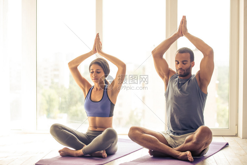 穿运动服的美黑人美女夫妇在做瑜伽时坐在席子上的莲图片