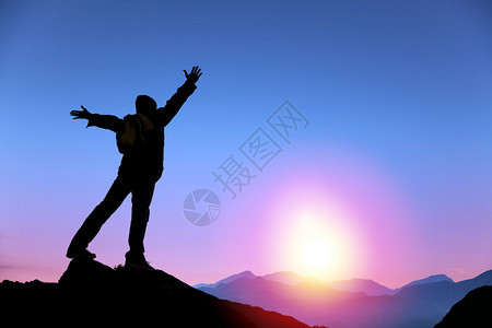 站在山顶看日出的年轻人图片