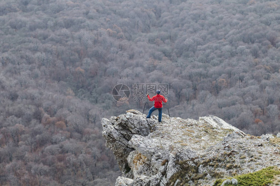 活跃的人爬到岩石边缘图片
