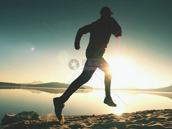 活跃的员赛跑者在日出岸上奔跑的剪影早晨在沙滩上进行健康生活方式锻炼男子图片