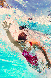 在游泳池游泳的年轻女子图片