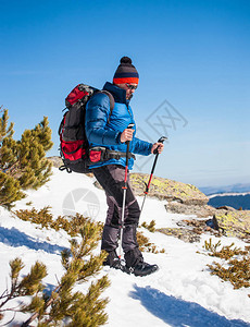 带着登山杖的人在山上攀登图片