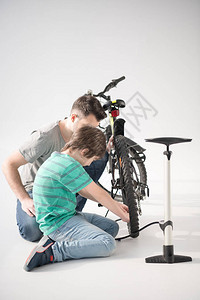 父亲和儿子的侧面视图用白色泵充图片