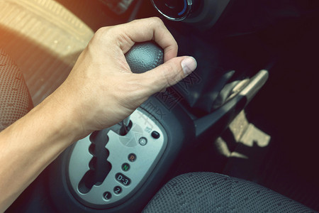 持有自动在汽车中传送自动传输的男驾驶手图片