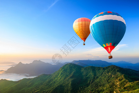 五颜六色的热气球飞过山图片