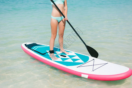 热带度假胜地在海面上站起船桨上的妇背景图片