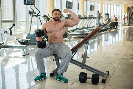 健身房里有肌肉男健壮的肌肉膀臂在露出体力来运动图片