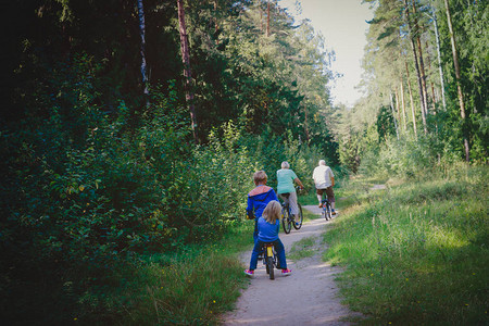 活跃的家庭有孩子在大自然中骑自行车图片