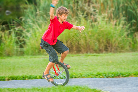 在自然背景下骑单车一轮自行车的年轻图片