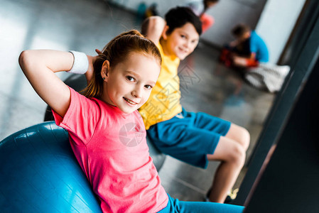 微笑的孩子在健身房用健身图片
