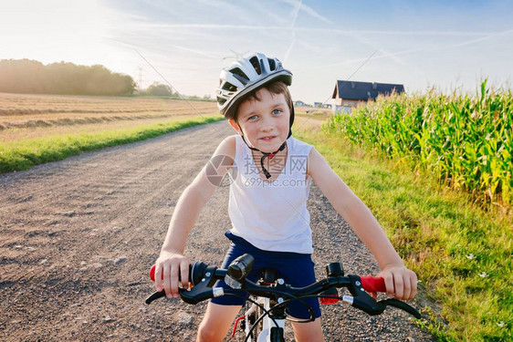 骑自行车时戴着脚单车头盔的快乐男孩骑图片