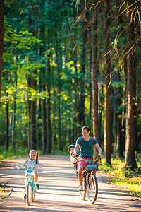 家庭在公园户外快乐骑自行车父亲和孩子们图片