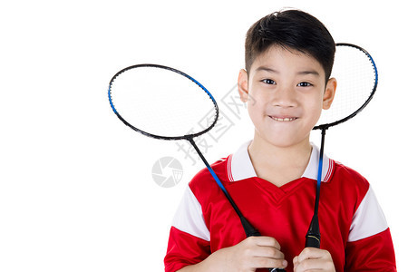 在羽毛球动作中快乐的亚洲男孩孤图片