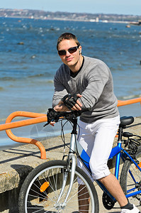海边骑自行车的帅哥肖像图片
