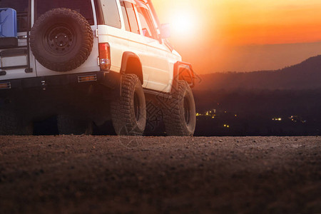运动车在泥地对着日落的天空旅行和背景图片