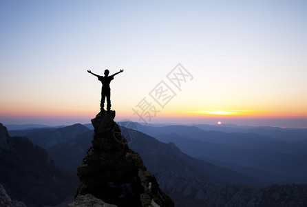 山顶上的人伸手去晒太阳图片